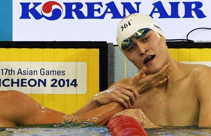 China's Sun Yang (R) is congratulated by an unseen South Korea's Park Taehwan as he celebrates after victory in the final for the men's 400m freestyle event during the 17th Asian Games at the Munhak Park Tae-hwan Aquatics Centre in Incheon on September 23, 2014.   AFP PHOTO / PHILIPPE LOPEZ